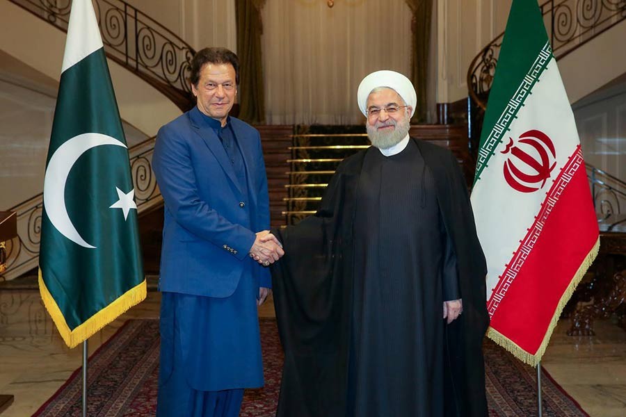 Iranian President Hassan Rouhani shakes hands with Pakistani Prime Minister Imran Khan in Tehran, Iran, on Sunday.  -Reuters Photo