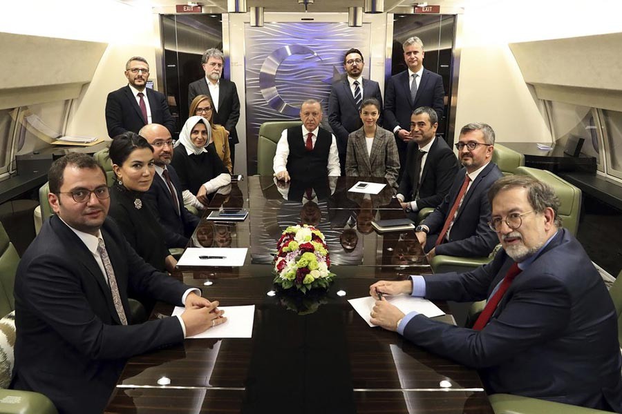 Turkey's President Recep Tayyip Erdogan, centre, is surrounded by journalists and pro-government academicians in his plane en route back from Baku, Azerbaijan on Tuesday. -AP Photo