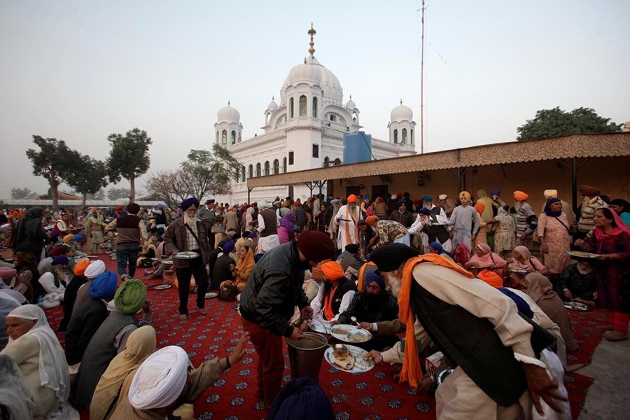 A man serves food to Sikhs from India outside the shrine of Guru Nanak Dev Ji, founder of Sikhism, during the groundbreaking ceremony of the Kartarpur border corridor, which will officially open November next, in Kartarpur, Pakistan on November 28, 2018 — Reuters/Files