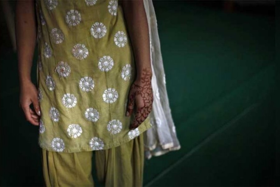 A 16-year-old girl with her hand decorated with henna stands inside a protection home on the outskirts of New Delhi, November 9, 2012. Reuters/Files