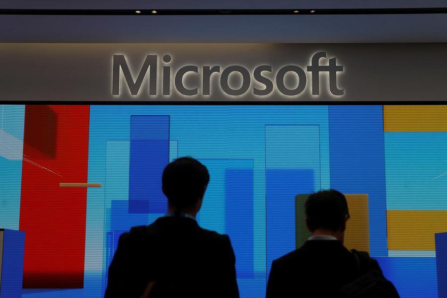 Visitors standing in front of a display screen at Microsoft's new Oxford Circus store ahead of its opening in London, Britain this year. -Reuters  File Photo