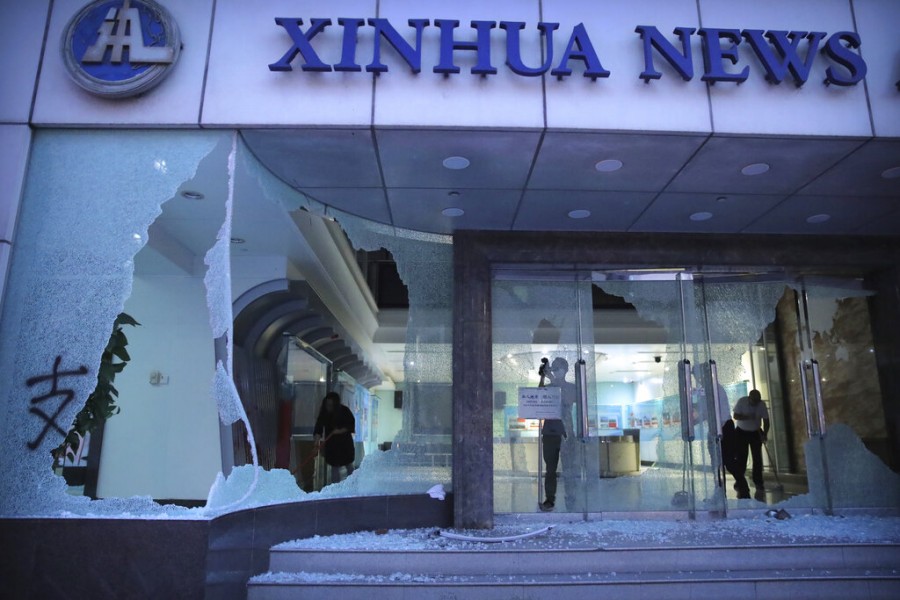 People stand inside the lobby of China's Xinhua News Agency after it was damaged by protesters in Hong Kong, Saturday, Nov 2, 2019. Photo: AP