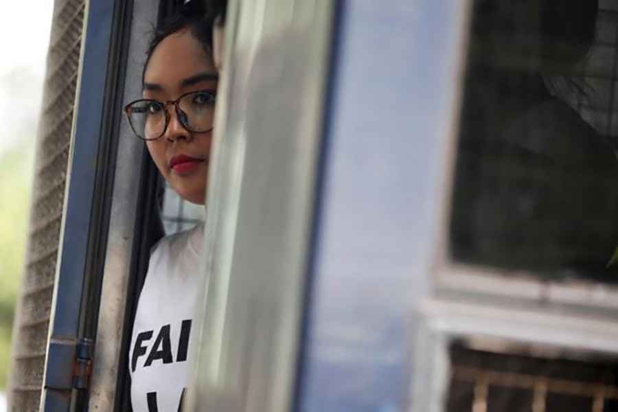 Kay Khaing Tun, a member of the Peacock Generation, a satirical poetry troupe, looks toward the media, inside a police van outside of Botataung court in Yangon, Myanmar on Monday — Reuters photo