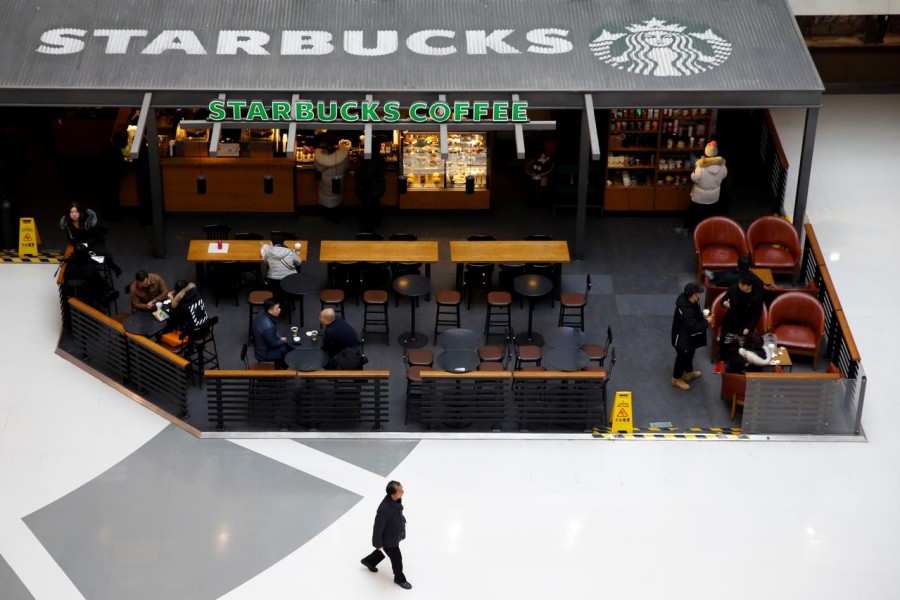 FILE PHOTO - People sit in a Starbucks cafe in a mall in Beijing, China, January 29, 2019. REUTERS/Thomas Peter