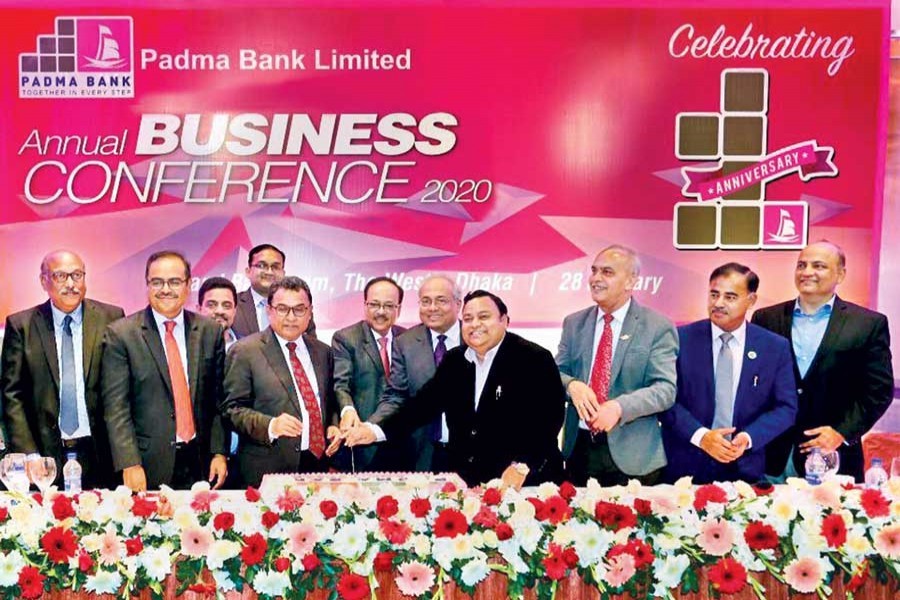 Finance Minister AHM Mustafa Kamal along with directors including Padma Bank Ltd chairman Chowdhury Nafeez Sarafat cutting a cake to mark 1st anniversary of Padma Bank Ltd and also the Annual Business Conference 2020 on Tuesday