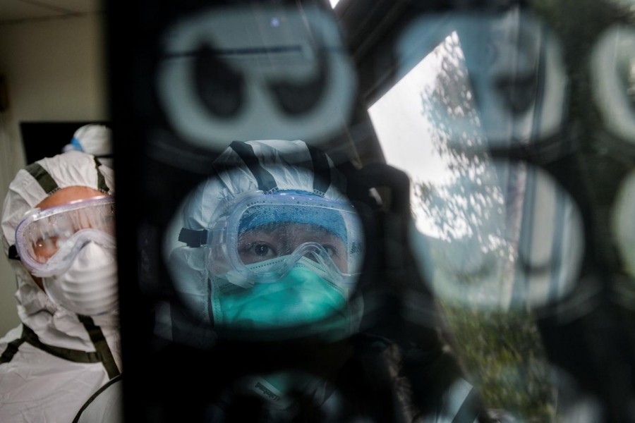 Medical workers in protective suits check a CT (computed tomography) scan image of a patient at a community health service centre, which has an isolated section to receive patients with mild symptoms caused by the novel coronavirus and suspected patients of the virus, in Qingshan district of Wuhan, Hubei province, China, February 8, 2020. China Daily via Reuters