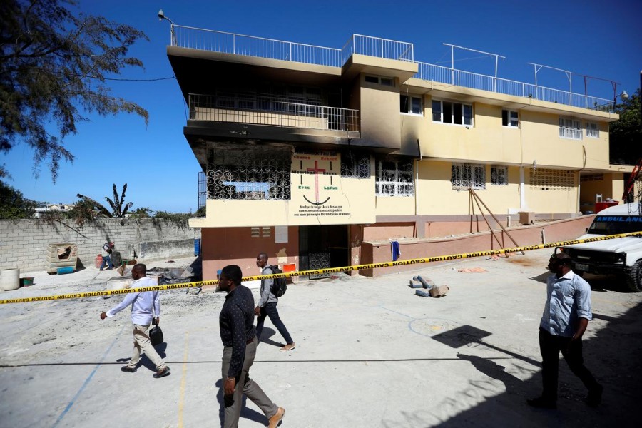 People walk outside an orphanage after part of it was destroyed in a fire, in Port-au-Prince, Haiti, February 14, 2020. REUTERS/Jeanty Junior Augustin