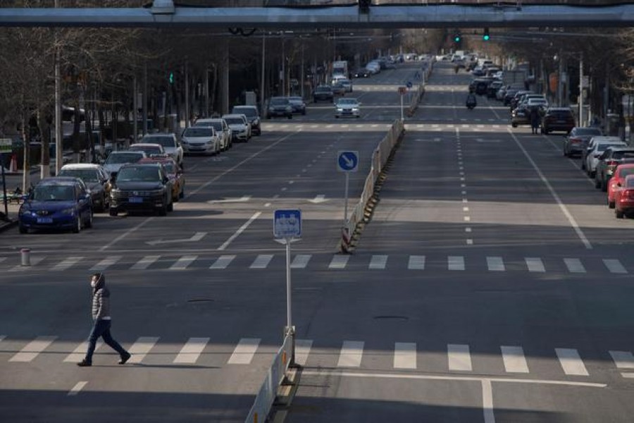 A man wearing a face mask crosses a road, as the country is hit by an outbreak of the novel coronavirus, in Beijing, China, February 15, 2020. Reuters