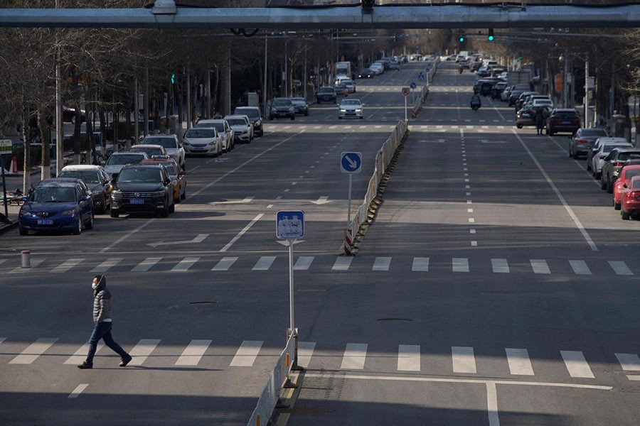 A man wearing a face mask crosses a road, as the country is hit by an outbreak of the novel coronavirus, in Beijing, China on Saturday. -Reuters Photo