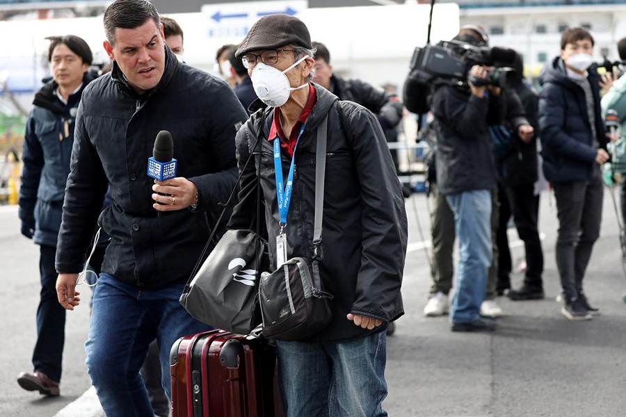 A member of the media approaches a passenger after he walked out from the cruise ship Diamond Princess at Daikoku Pier Cruise Terminal in Yokohama, south of Tokyo, Japan on February 19, 2020 — Reuters photo