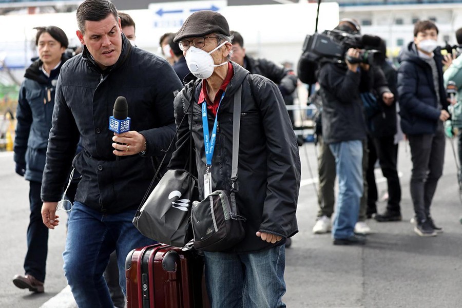 A member of the media approaches a passenger after he walked out from the cruise ship Diamond Princess at Daikoku Pier Cruise Terminal in Yokohama, south of Tokyo, Japan, February 19, 2020. Reuters