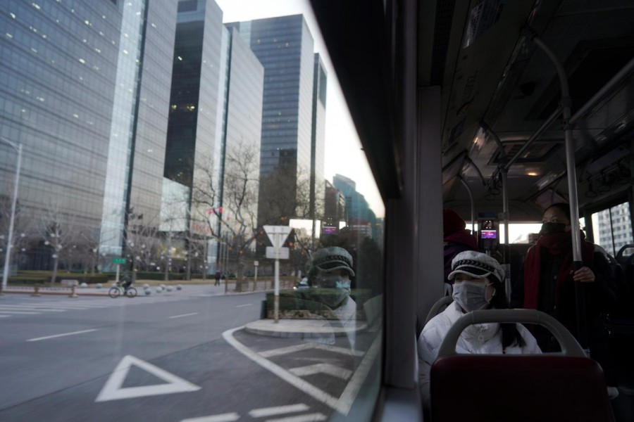 Passengers wearing face mask look on from inside a bus, following an outbreak of the novel coronavirus in the country, in Beijing's central business district, China, February 21, 2020. Reuters