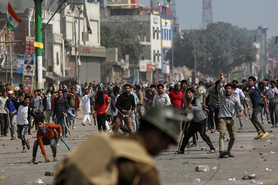 Demonstrators opposing new citizenship law throw pieces of bricks towards riot police and those supporting the law, during a clash in New Delhi, India on February 24, 2020 — Reuters photo