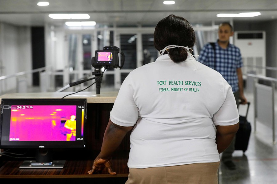 An official monitors thermal scanners as a passenger walks past upon arrival of a flight into Lagos, Nigeria on January 22, 2020 — Reuters/Files