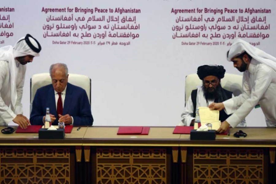 Mullah Abdul Ghani Baradar, the leader of the Taliban delegation, signs an agreement with Zalmay Khalilzad, US envoy for peace in Afghanistan, at a signing agreement ceremony between members of Afghanistan's Taliban and the US in Doha, Qatar February 29, 2020. REUTERS/Ibraheem al Omari