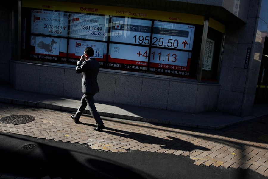 A man walks past an electronic board showing stock prices outside a brokerage in Tokyo, Japan, January 04, 2017 —Reuters/Files