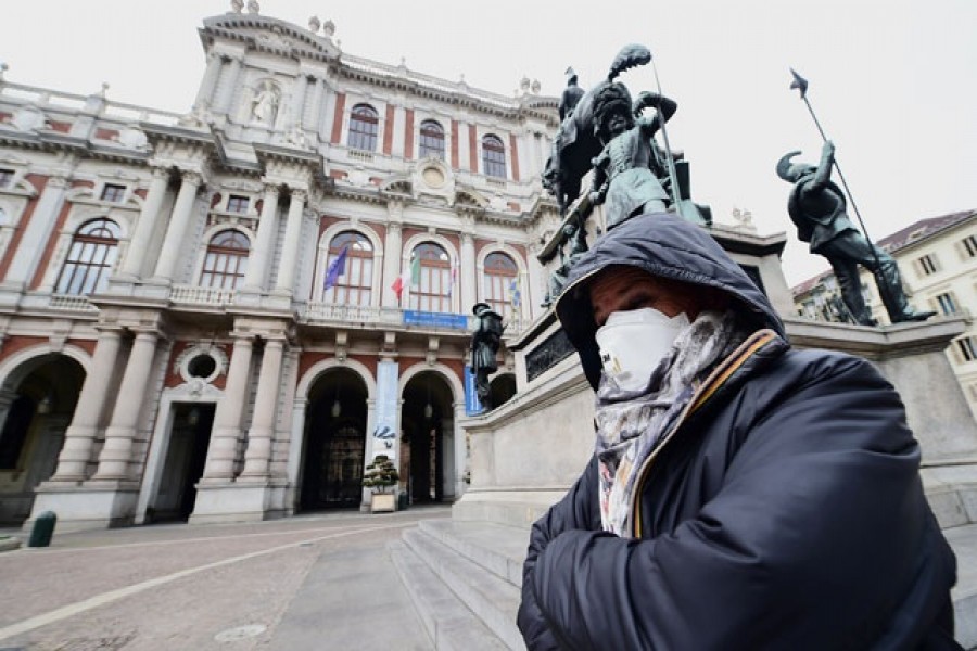 A woman wears a mask at the Carlo Alberto square, after the government decree to close cinemas, schools and urge people to work from home and not stand closer than one metre to each other, in Turin, Italy, March 05, 2020 — Reuters