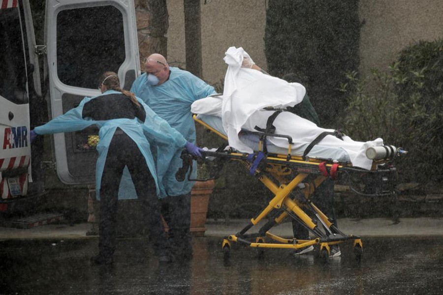 Medics transport a patient through heavy rain into an ambulance at Life Care Center of Kirkland, the long-term care facility linked to several confirmed coronavirus cases in the state, in Kirkland, Washington, US on March 7, 2020 — Reuters photo