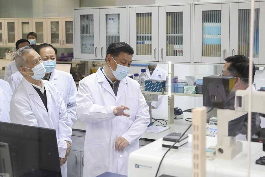 Xi Jinping, centre, wearing a protective face mask, talks to a medical staff member during his visit to the Academy of Military Medical Sciences in Beijing — AP files