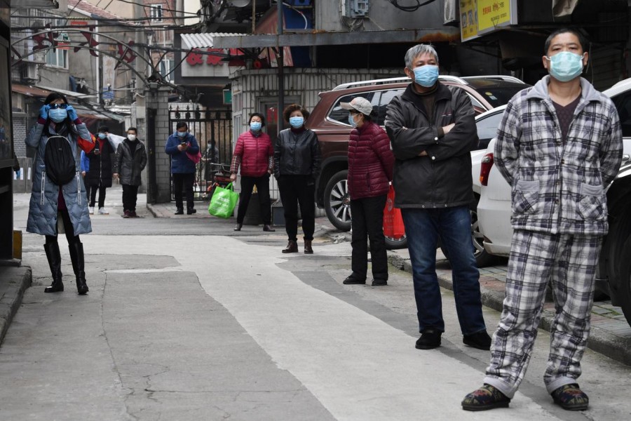 Residents line up to collect vegetables purchased through group orders at a residential area in Wuhan, the epicentre of the novel coronavirus outbreak, Hubei province, China March 5, 2020. REUTERS/Stringer