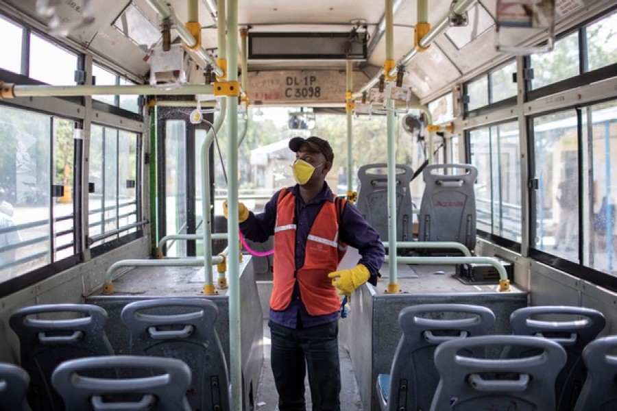 A worker wearing a protective mask takes part in disinfecting a public bus, amid coronavirus fears, in New Delhi. — Reuters