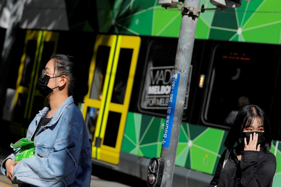 FILE PHOTO: People wearing face masks walk on Bourke Street after cases of the coronavirus were confirmed in Melbourne, Victoria, Australia, January 29, 2020. REUTERS/Andrew Kelly/File Photo