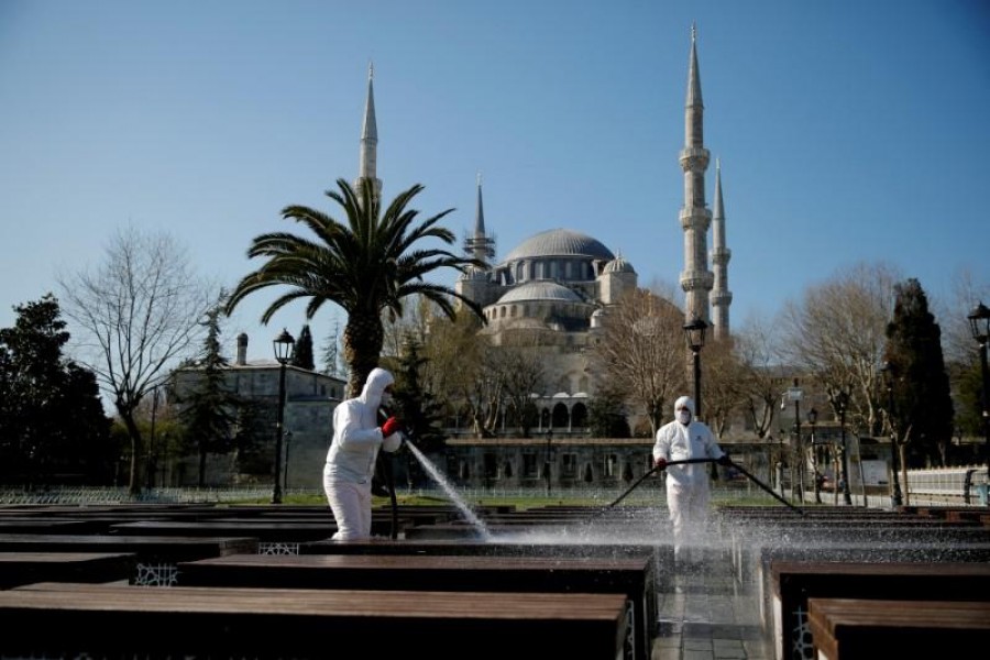 Workers in protective suits disinfect the park in front of the Blue Mosque in response to the spread of coronavirus disease (COVID-19) in Istanbul,Turkey March 21, 2020. REUTERS/Kemal Aslan