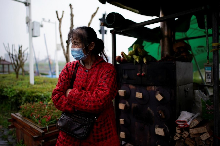 Li Yu, 55, a pedlar selling corn, wears a face mask at an ancient city wall in Jingzhou, after the tourist attraction reopened as the lockdown was eased in Hubei province, the epicentre of China's coronavirus disease (COVID-19) outbreak, March 26, 2020. REUTERS/Aly Song