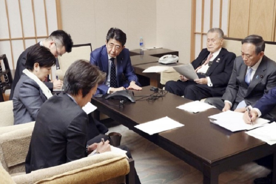 Japan's prime minister Shinzo Abe, president of the Tokyo 2020 Organising Committee Yoshiro Mori, Tokyo Governor Yuriko Koike, Olympic minister Seiko Hashimoto and chief cabinet secretary Yoshihide Suga attend a telephone conference with International Olympic Committee (IOC) president Thomas Bach (not pictured) at Abe's official residence in Tokyo, Japan, March 24, 2020, in this photo released by Japan's Cabinet Public Relations Office via Kyodo. Mandatory credit Japan's Cabinet Public Relations Office via Kyodo/via Reuters