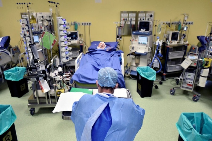 A member of the medical staff in a protective suit is seen in front of a patient suffering from coronavirus disease (COVID-19) in an intensive care unit at the San Raffaele hospital in Milan, Italy, March 27, 2020. —Reuters