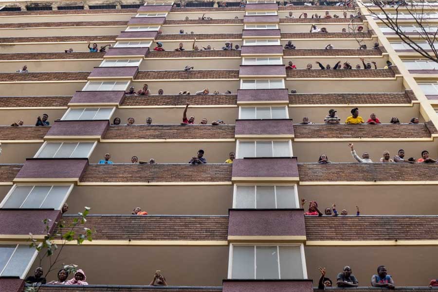 Residents of the densely populated Hillbrow neighborhood of downtown Johannesburg in South Africa, confined in an attempt to prevent the spread coronavirus, standing and waving from their balconies on Friday. –AP Photo