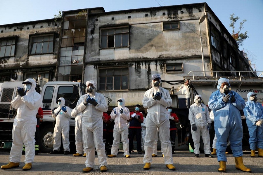 Workers wearing protective suits pray before a disinfection operation, during the movement control order due to the outbreak of the coronavirus disease (COVID-19), in Kuala Lumpur, Malaysia April 01, 2020. — Reuters