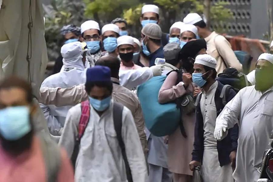 Men wearing protective masks waiting for a bus that will take them to a quarantine facility, amid concerns about the spread of coronavirus disease (COVID-19), in Nizamuddin area of New Delhi in India on Tuesday. –Reuters Photo