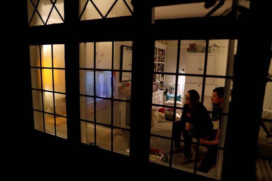 An isolated couple, Nick and Cat Mehta, watch British Prime Minister Boris Johnson’s press conference as the spread of coronavirus disease (COVID-19) continues in Weybridge, Britain on March 23, 2020 — Reuters/Files