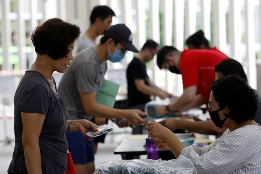 Residents receiving free reusable masks distributed by the government at a community centre in Singapore on Sunday –Reuters Photo