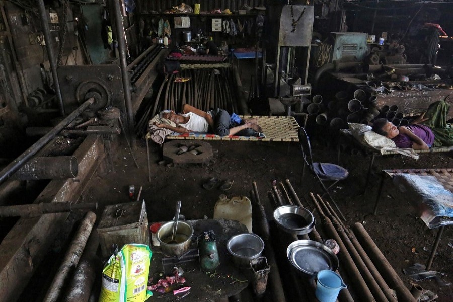 Migrants workers rest inside a workshop after it was shut due to the 21-day nationwide lockdown to slow the spread of the coronavirus disease (COVID-19), in Mumbai, India, April 07, 2020. – Reuters