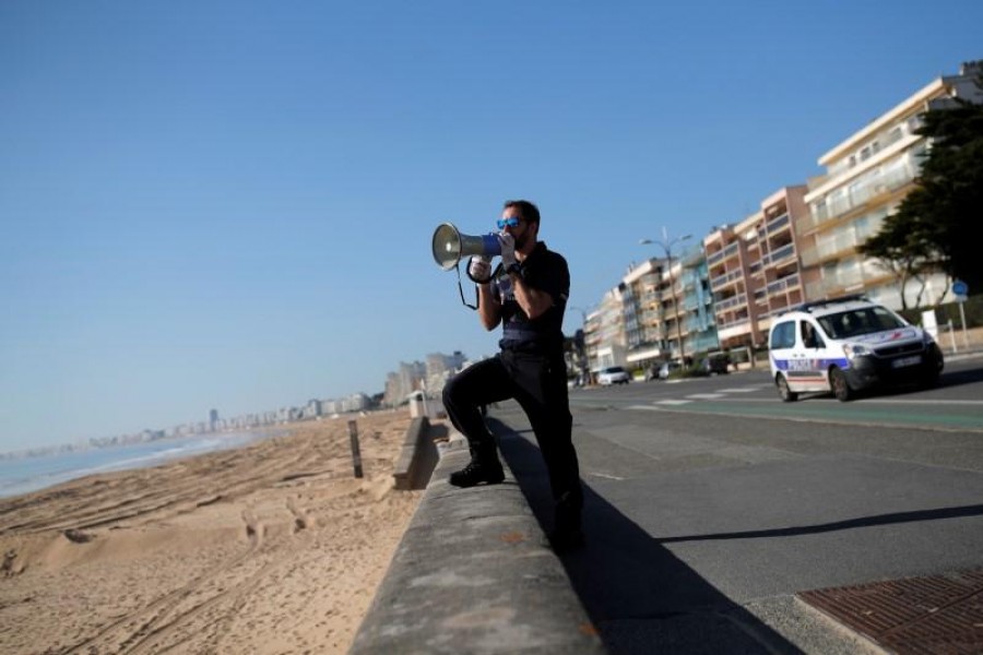 French police evacuate the beach in Pornichet near La Baule as a lockdown is imposed to slow the rate of the coronavirus disease (COVID-19) in France, March 18, 2020. REUTERS/Stephane Mahe