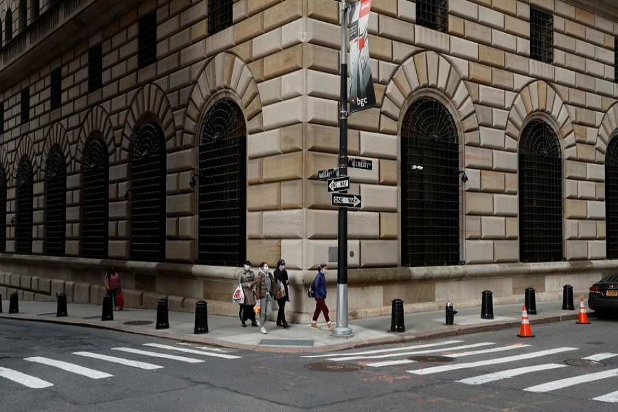 People walk wearing masks outside The Federal Reserve Bank of New York in New York City, U.S., March 18, 2020. — Reuters/Files