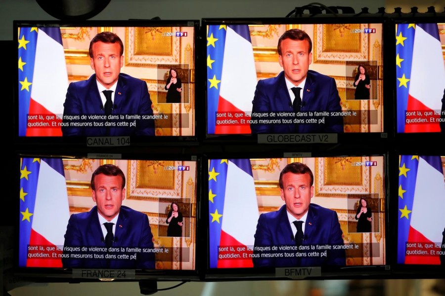 French President Emmanuel Macron is seen as he addresses the nation about the coronavirus disease (COVID-19) outbreak, on television screens in Paris, France, April 13, 2020. REUTERS/Charles Platiau