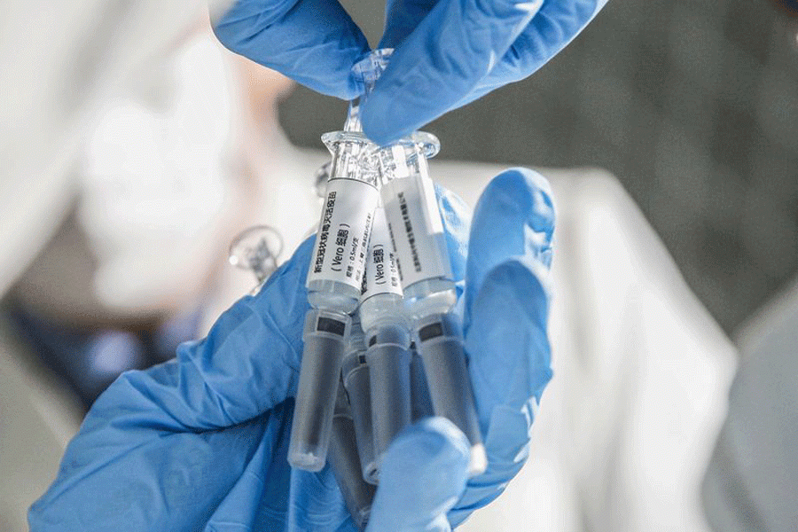 A staff member displays samples of the COVID-19 inactivated vaccine at Sinovac Biotech Ltd., in Beijing, capital of China, March 16, 2020. (Xinhua/Zhang Yuwei)   