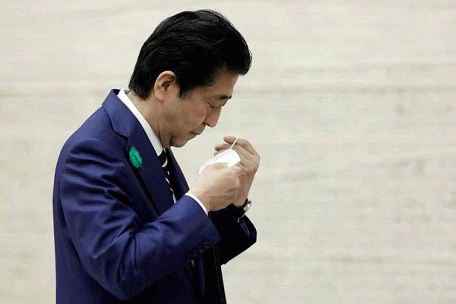 Japan's Prime Minister Shinzo Abe puts on a protective mask after a news conference at the prime minister's official residence in Tokyo, Japan Apr 17, 2020. REUTERS   