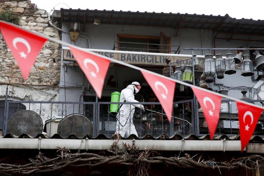 A worker in a protective suit sprays disinfectant at Grand Bazaar, known as the Covered Bazaar, to prevent the spread of coronavirus disease (COVID-19), in Istanbul, Turkey on March 25, 2020 — Reuters/Files