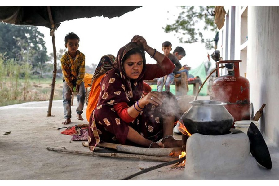 Gyanvati, a migrant worker, cooks food for her family after she returned home from New Delhi during nationwide lockdown in India to slow the spread of the coronavirus, in Jugyai village in the central state of Madhya Pradesh, India, Apr 8, 2020. REUTERS