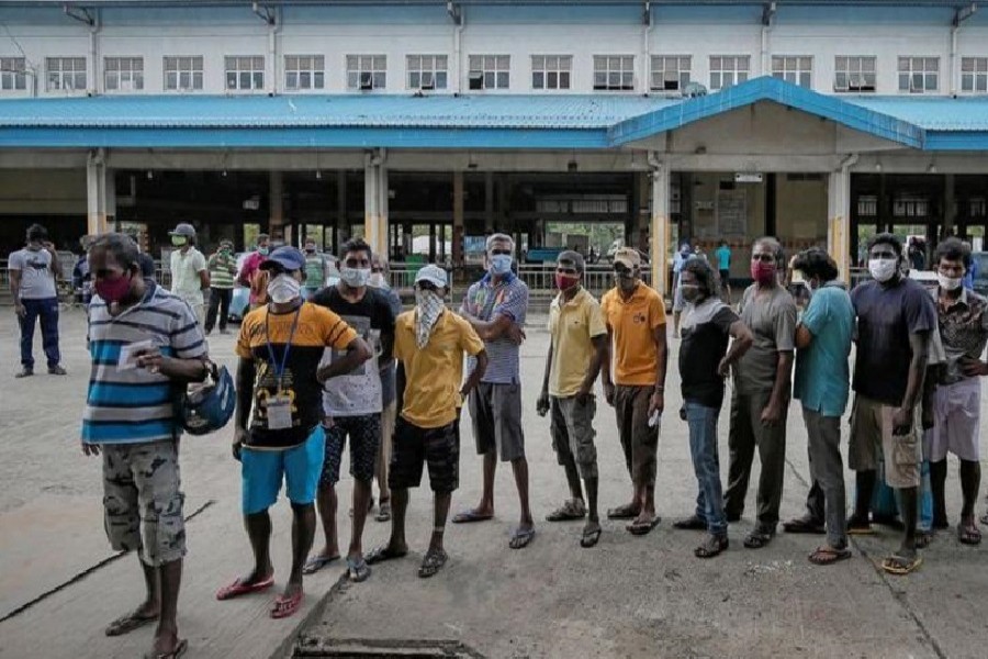 People stand in a line waiting for their turn as health officials use swabs to collect samples at a building during the curfew amid concerns about the spread of the coronavirus disease (COVID-19), in Colombo, Sri Lanka, April 22, 2020. — Reuters