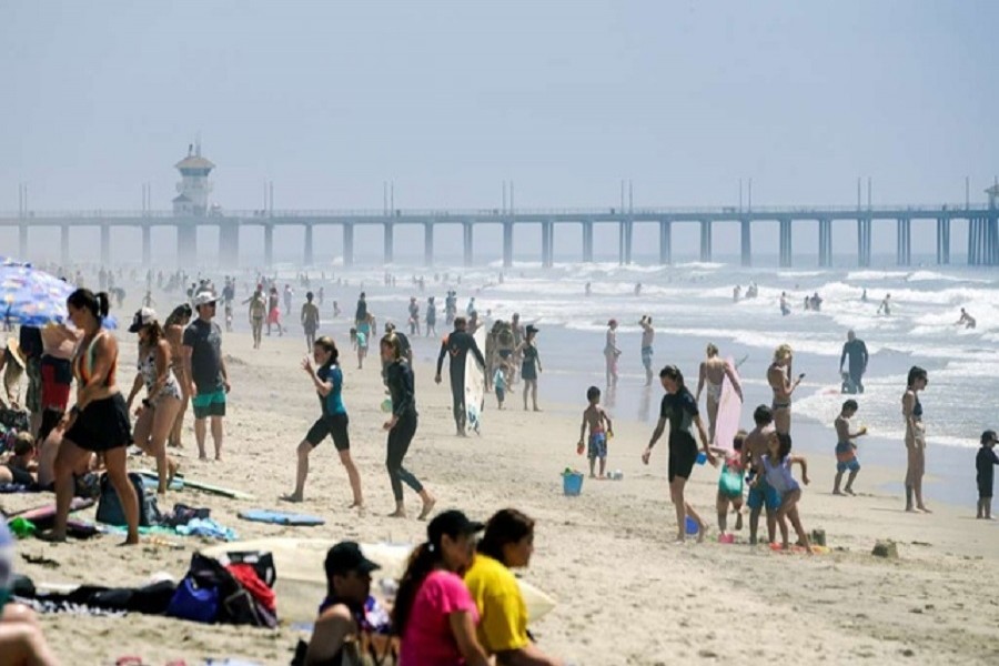 People walk up and down Huntington City Beach during the outbreak of the coronavirus disease (COVID-19), in Huntington Beach, California, US, April 25, 2020. — Reuters