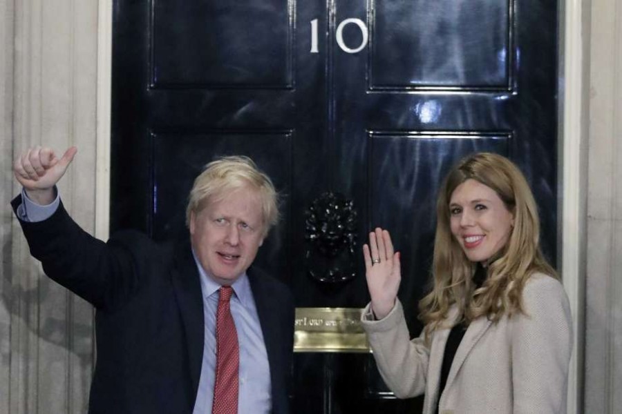 In this Friday, Dec. 13, 2019 file photo, Britain's Prime Minister Boris Johnson and his partner Carrie Symonds wave from the steps of number 10 Downing Street in London. Photo: AP