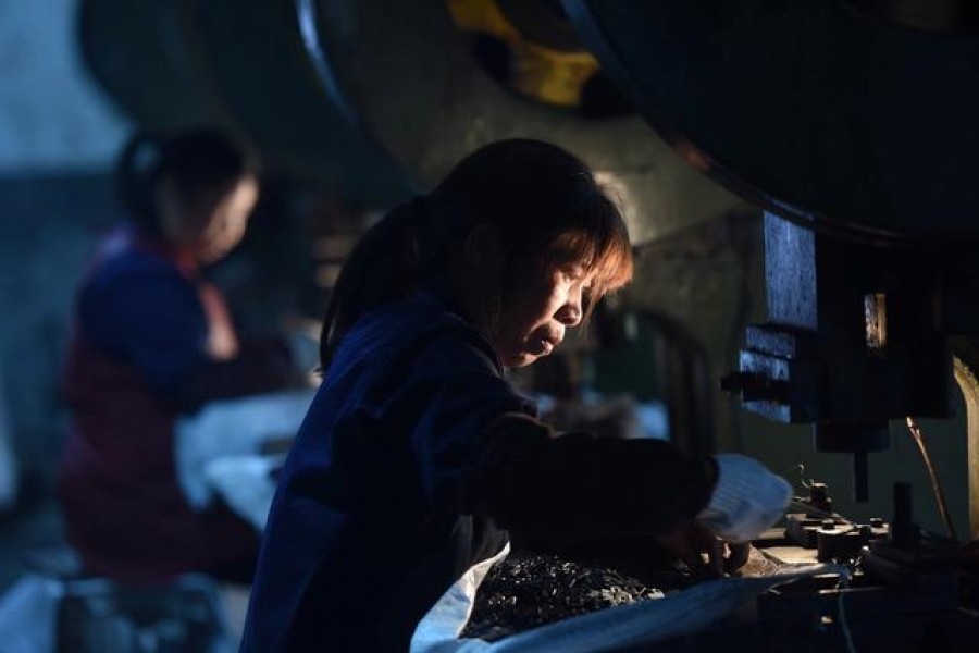 Employees work on a production line manufacturing metal parts for furniture at a factory in Hangzhou, Zhejiang province, China April 30, 2020. China Daily via REUTERS