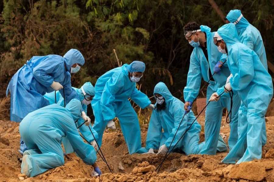 A relative reacts as others including a health worker lower the body of a man who died from the coronavirus disease (COVID-19), for burial at a graveyard in New Delhi, India, May 06, 2020. — Reuters