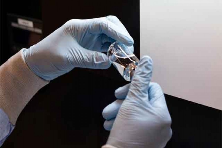 FILE PHOTO: A lab technician visually inspects a filled vial of investigational coronavirus disease (COVID-19) treatment drug remdesivir at a Gilead Sciences facility in La Verne, California, US March 11, 2020. Gilead Sciences Inc/Handout via REUTERS