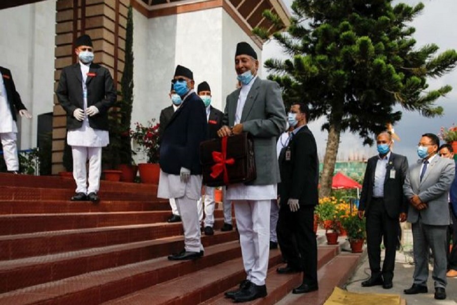 Nepal's Finance Minister Yuba Raj Khatiwada displays his briefcase with budget details for the fiscal year 2020-21 to the media upon his arrival at the parliament, during the sixty-sixth day of the lockdown imposed by the government amid concerns about the spread of the coronavirus disease (COVID-19), in Kathmandu, Nepal, May 28, 2020. — Reuters